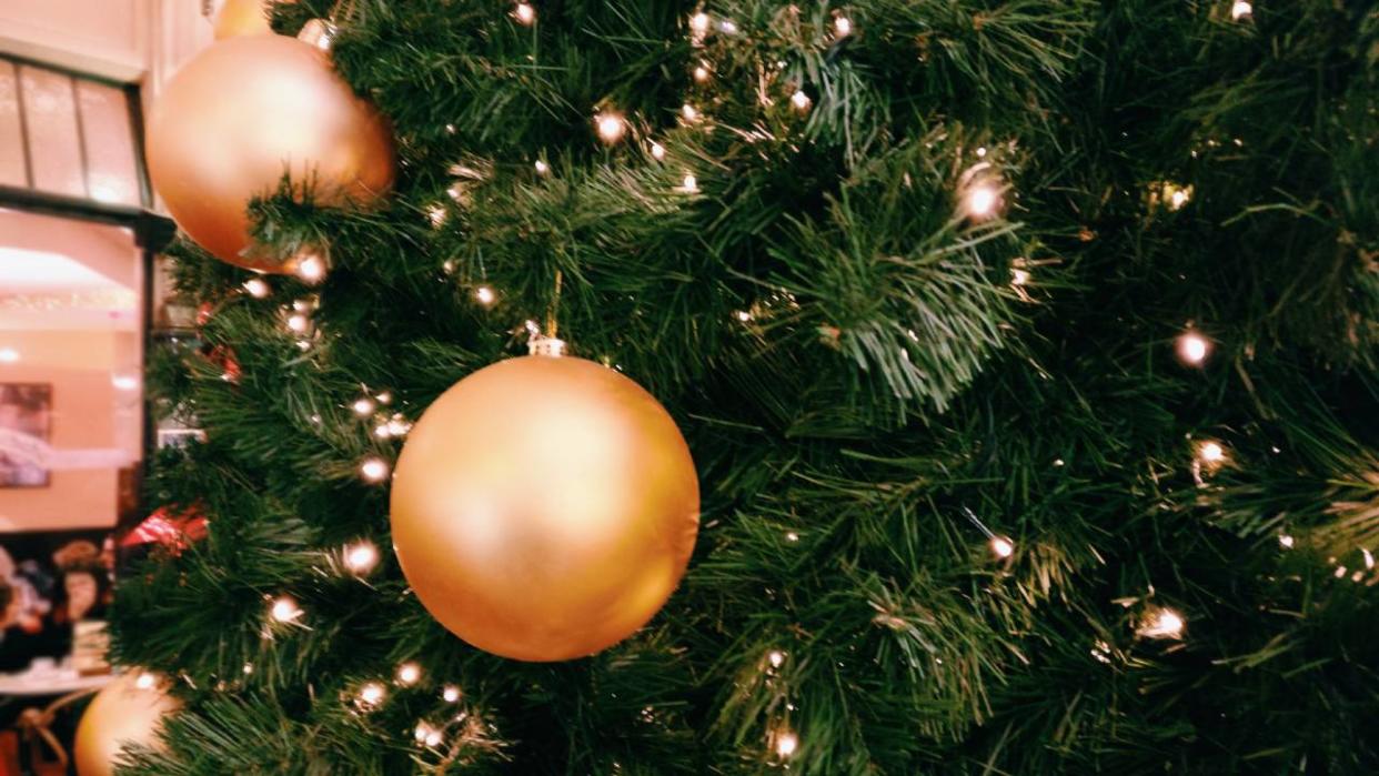  Close up of gold lights and baubles on a Christmas tree. 