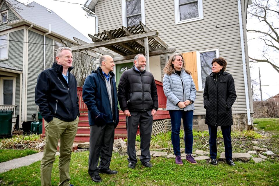 From left, Brent Taylor, Habitat for Humanity Capital Region president, Mayor Andy Schor, Ingham County Treasurer Alan Fox, Margaret Tassaro, president of the Eastfield Neighborhood Association, and Margaret Dimond, Sparrow Hospital president, talk near one of several properties Sparrow Health System will hand over to the Ingham County Land Bank and Habitat for Humanity on Wednesday, April 3, 2024, in Lansing. The plan is to renovate and sell the properties as single family housing.