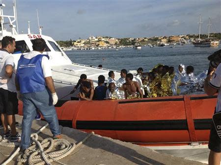 Rescued migrants arrive onboard a coastguard vessel at the harbour of Lampedusa October 3, 2013. REUTERS/Nino Randazzo/ASP press office/Handout via Reuters