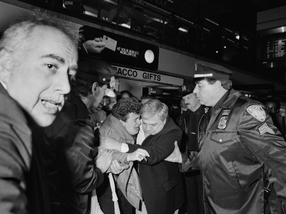 At JFK Airport here, a woman, screaming "My Baby! My Baby!" is led away after she learned that Pan Am Flight 103, with 258 people aboard, had crashed in Scotland.