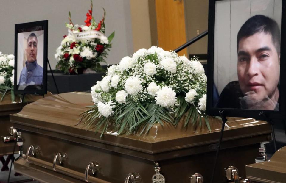 Portraits of Víctor Cirilo Hernández (far left) and Fidel Filomeno Ojeda are displayed above their caskets at a funeral mass for the seven farmworkers who died in a Feb. 23 crash in rural Madera County. The mass was held at the Kerman High School multi-purpose room on March 9, 2023.