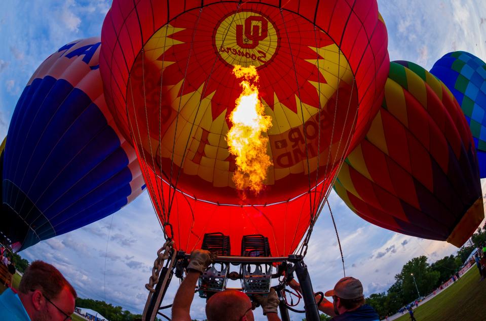 Crews work to inflate a hot air balloon during the morning balloon glow and flights for the FireLake Fireflight Balloon Fest in Shawnee Okla. on Friday, Aug. 13, 2021.