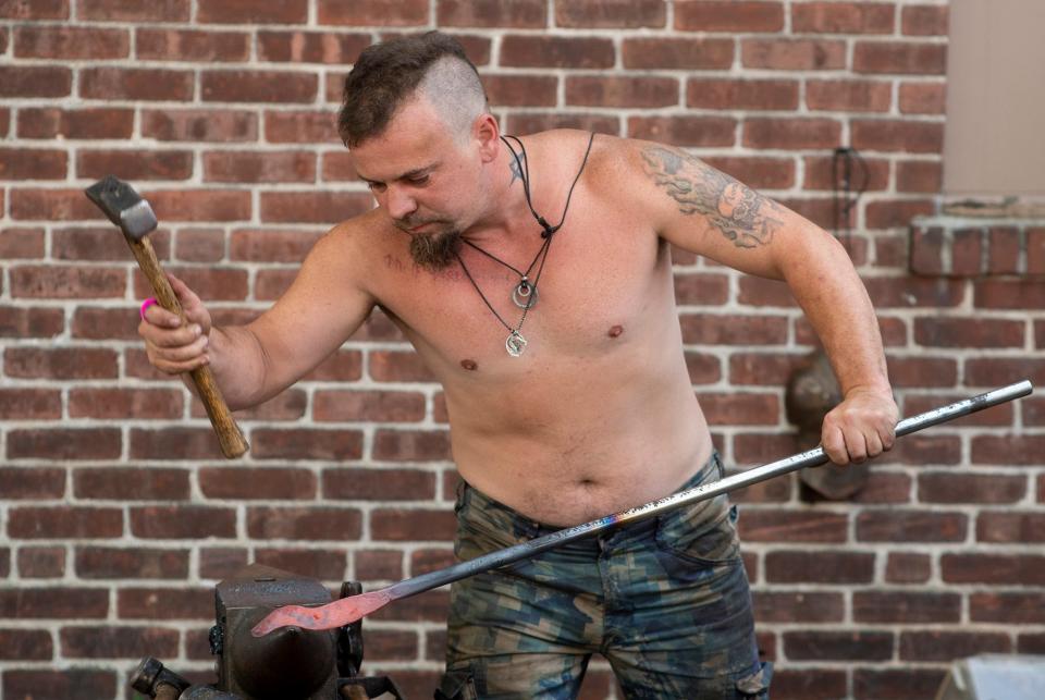 Blacksmith Jason Scott forges a knife at The Workshop booth during stART on the Street.