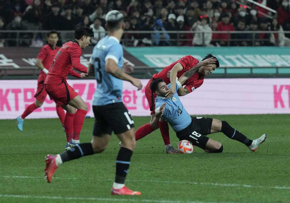 Uruguay's Maximiliano Gomez Gonzalez, second right, fights for the ball against South Korea's Kim Min-jae during an international friendly soccer match between South Korea and Uruguay in Seoul, Sough Korea, Tuesday, March 28, 2023. (AP Photo/Ahn Young-joon)