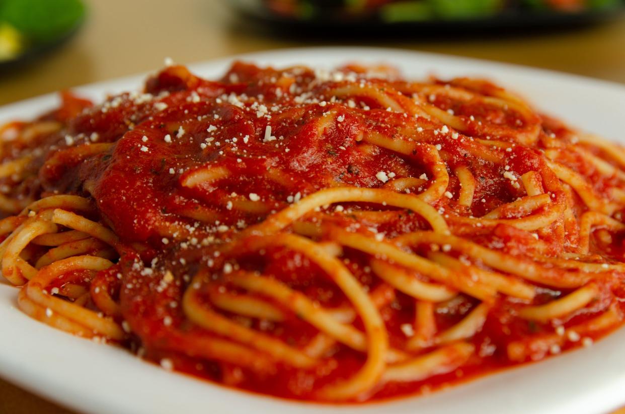 Spaghetti with tomato sauce on a white plate.