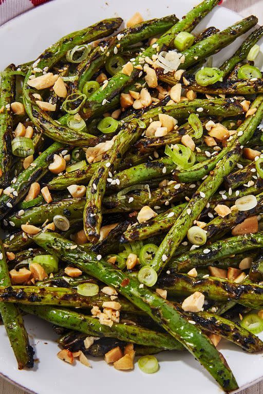 <p>If you're cooking over an actual grill, place a heavy-duty piece of foil over the grates before adding the green beans. It'll prevent all the veg from falling through the cracks. Not a fan of peanuts? Use any crushed nuts or seeds here for crunch!</p><p>Get the <strong><a href="https://www.delish.com/cooking/recipe-ideas/a22243865/grilled-green-beans-recipe/" rel="nofollow noopener" target="_blank" data-ylk="slk:Grilled Green Beans recipe;elm:context_link;itc:0" class="link ">Grilled Green Beans recipe</a></strong>.</p>