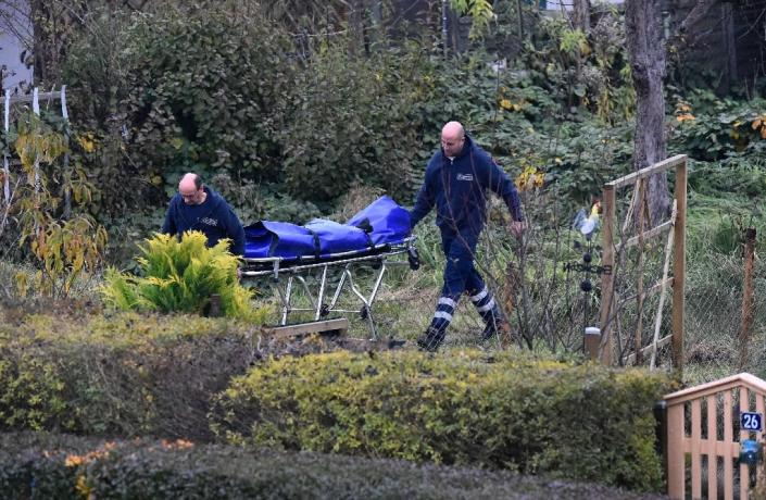 Forensic doctors push a stretcher through the garden allotment "Am Eckbusch" in Luckenwalde, south of Berlin, on October 30, 2015 (AFP Photo/Tobias Schwarz)