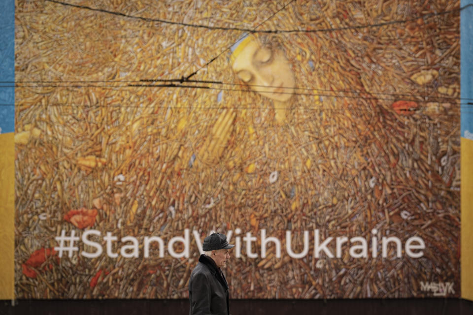 A man walks by a large billboard in Kyiv, Ukraine, Friday, March 3, 2023. Speaking at the U.N. conference on disarmament, Russian Deputy Foreign Minister Sergei Ryabkov denounced the U.S. and its allies for openly declaring the goal of defeating Russia in a "hybrid" war, arguing that it violates their obligations under international agreements and is fraught with the war in Ukraine spilling out of control. (AP Photo/Vadim Ghirda)