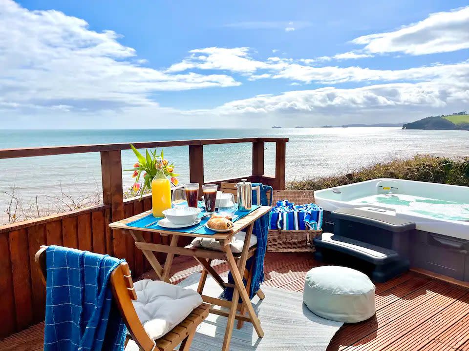 <p><a class="link " href="https://airbnb.pvxt.net/MXPNoJ" rel="nofollow noopener" target="_blank" data-ylk="slk:SEE INSIDE">SEE INSIDE</a></p><p>A scenic Airbnb with a hot tub near the beach. this rental in the town of Dawlish is just 30 minutes from Exeter. It's a great house for a family or group looking to enjoy some sea air and proper relaxation. You'll find outdoor space including a cute breakfast spot and the perfectly placed hot tub for you to enjoy the setting. Inside, the dining space also allows you to enjoy the views from the multiple windows.</p><p><strong>Sleeps:</strong> 8</p><p><strong>Highlight: </strong>The mesmerising sea view</p><p>Remember to bring: SPF and your shades for sunny mornings on the terrace. There are sun loungers to relax while you soak up the vitamin D.</p>