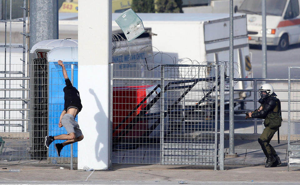 A fan throws a chair at a riot police in Volos