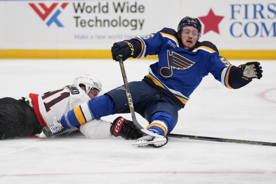 St. Louis Blues' Hugh McGing (56) is tripped up by Ottawa Senators' Vladimir Tarasenko, left, during the second period of an NHL hockey game Thursday, Dec. 14, 2023, in St. Louis. (AP Photo/Jeff Roberson)