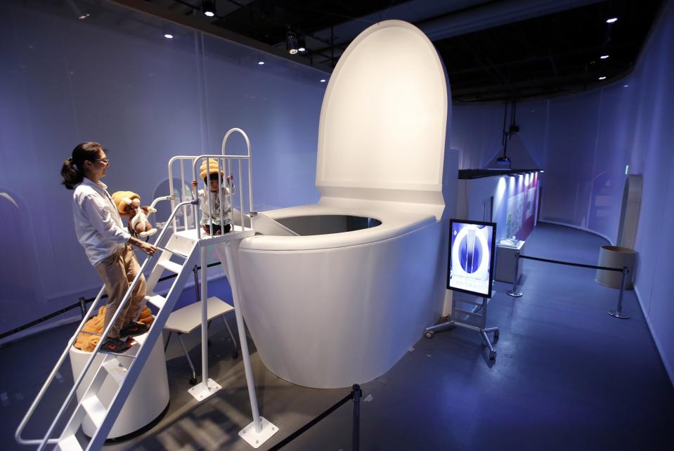 RNPS - REUTERS NEWS PICTURE SERVICE - PICTURES OF THE YEAR 2014 - ODDLY A girl wearing a faeces-shaped hat prepares to slide down into a five-metre (16.4-ft) toilet at an exhibition titled "Toilet !? Human Waste and Earth's Future" at the Miraikan National Museum of Emerging Science and Innovation in Tokyo in this July 3, 2014 file photo. REUTERS/Issei Kato/Files (JAPAN - Tags: SOCIETY HEALTH ENVIRONMENT TPX IMAGES OF THE DAY)