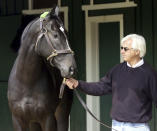 FILE - Trainer Bob Baffert walks 2015 Kentucky Derby and Preakness winner War Emblem in the barns at Pimlico Race Course, in Baltimore, Sunday May 19, 2002. Baffert will miss the race for the third consecutive year. He served a two-year suspension by Churchill Downs Inc. after his 2021 winner Medina Spirit was disqualified for a failed drug test. But the track’s corporate ownership meted out an additional year of punishment. (AP Photo/Alex Dorgan-Ross, File)