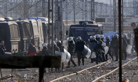 Greek police officers guard the perimeter where hundreds of migrants, who were stranded on the Greek-Macedonian border and blocking rail traffic, are gathered in tents after a police operation near the village of Idomeni, Greece, December 9, 2015. REUTERS/Ognen Teofilovski