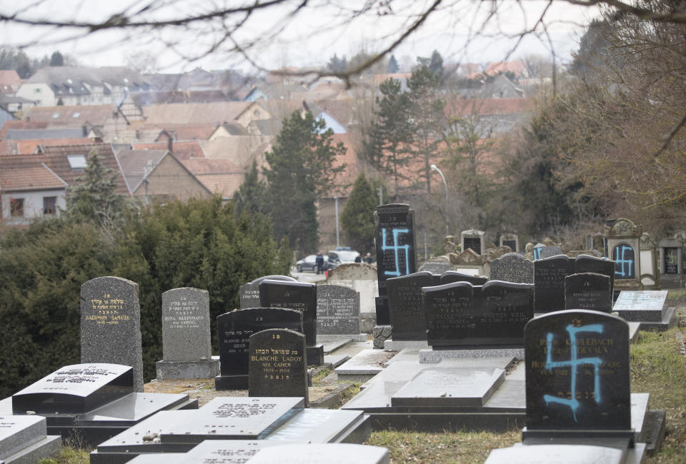 Vandalized tombs with tagged swastikas are pictured in the Jewish cemetery of Quatzenheim, eastern France, Tuesday, Feb.19, 2019. Marches and gatherings against anti-Semitism are taking place across France following a series of anti-Semitic acts that shocked the country. (AP Photo/Jean-Francois Badias)