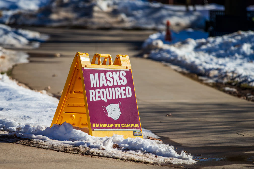 A sign alerting people that masks are required on campus