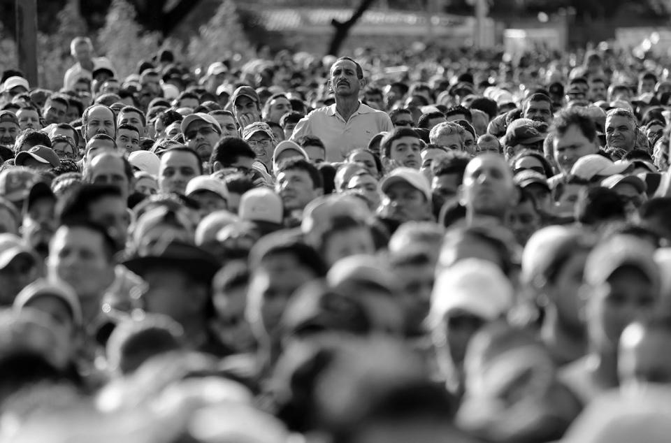 HOLD FOR DARIO LOPEZ - A man peaks over the crowd waiting to cross the border into Colombia through the Simon Bolivar bridge in San Antonio del Tachira, Venezuela Sunday July 17, 2016. (AP Photo/Ariana Cubillos)