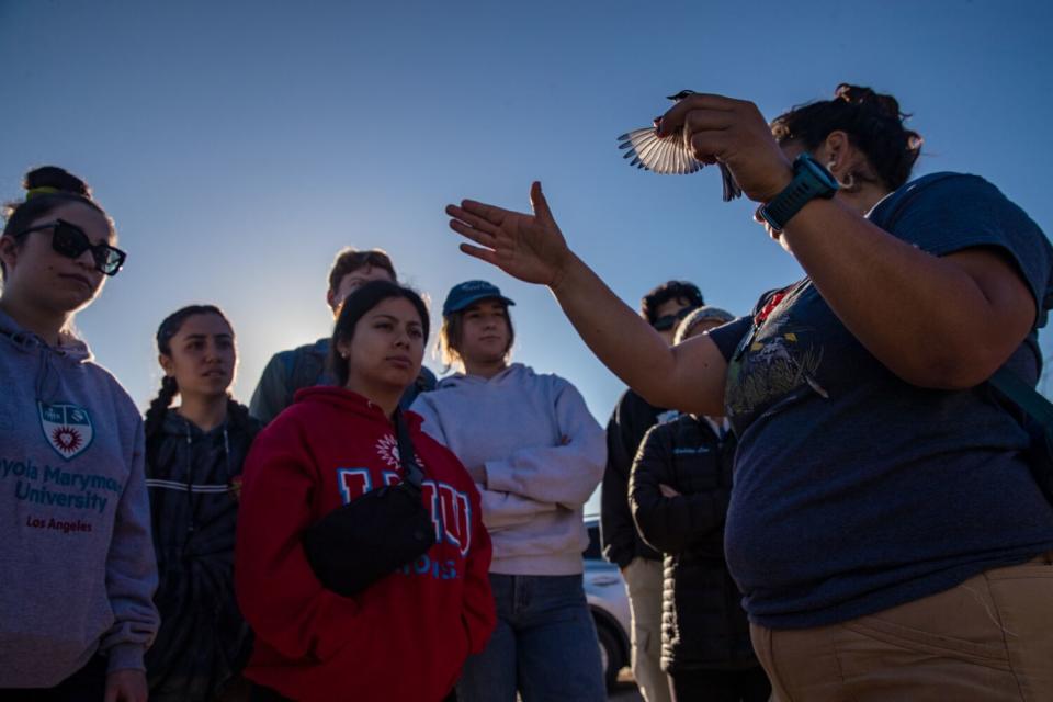 Students watch a woman holding a bird