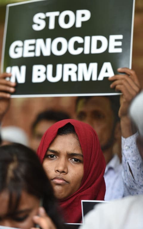 Rohingya Muslim refugees along with Indian supporters hold placards against human rights violations in Myanmar during a protest in New Delhi on September 5, 2017 - Credit: AFP