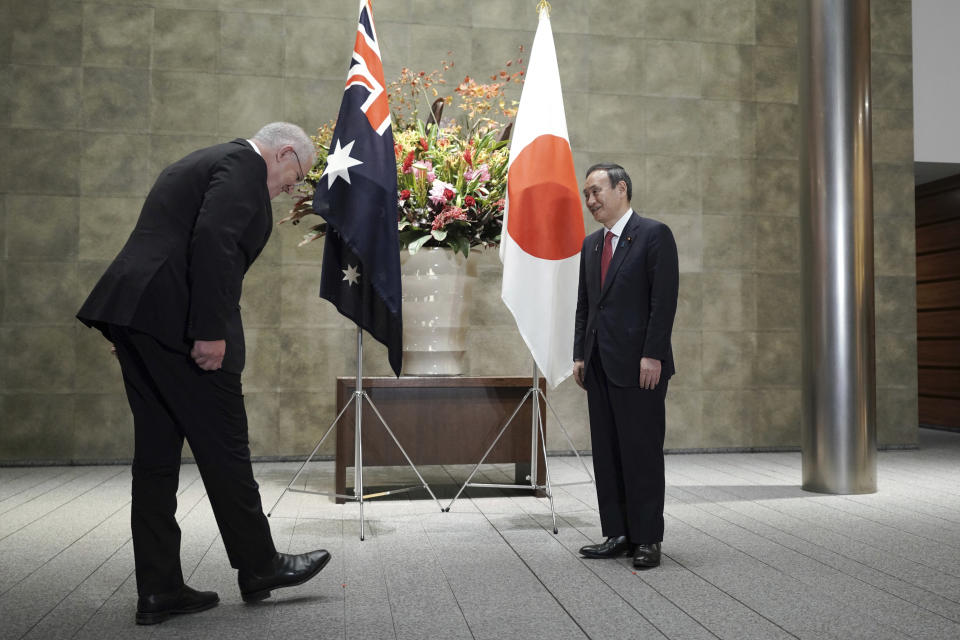 Australian Prime Minister Scott Morrison, left, greets Japanese Prime Minister Yoshihide Suga prior to the official welcome ceremony at Suga's official residence in Tokyo Tuesday, Nov. 17, 2020. Morrison is in Japan to hold talks with Suga to bolster defense ties between the two U.S. allies to counter China’s growing assertiveness in the Asia-Pacific region. (AP Photo/Eugene Hoshiko, Pool)