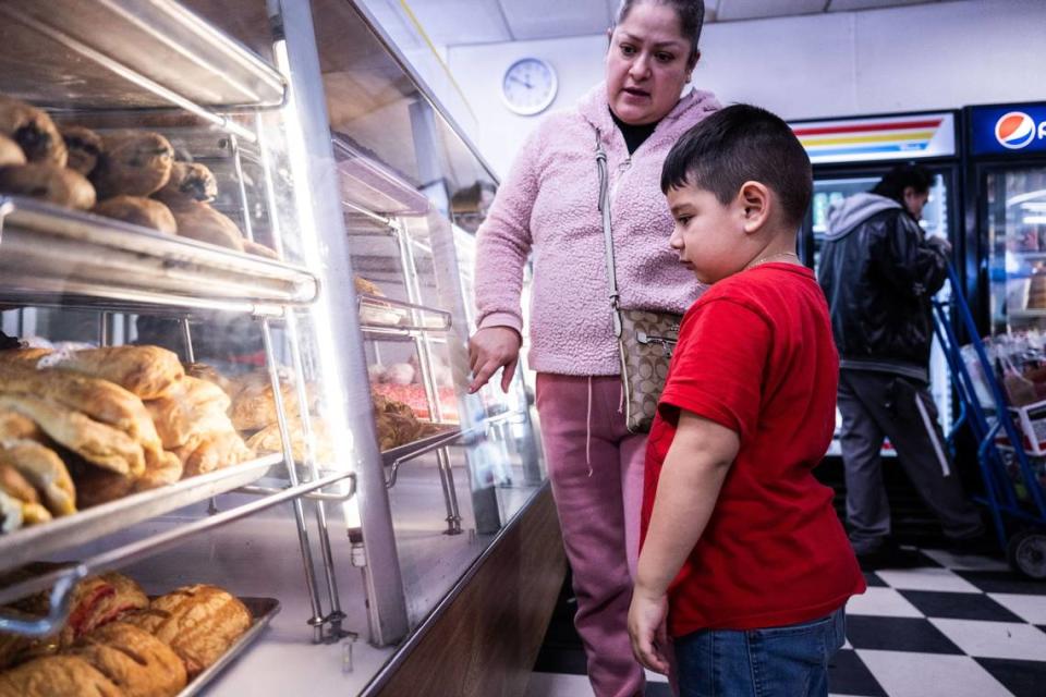 Erika Caballero and her five-year-old son Omar pick pastries at La Esperanza Bakery on Franklin Boulevard on Tuesday, Feb. 13, 2024.