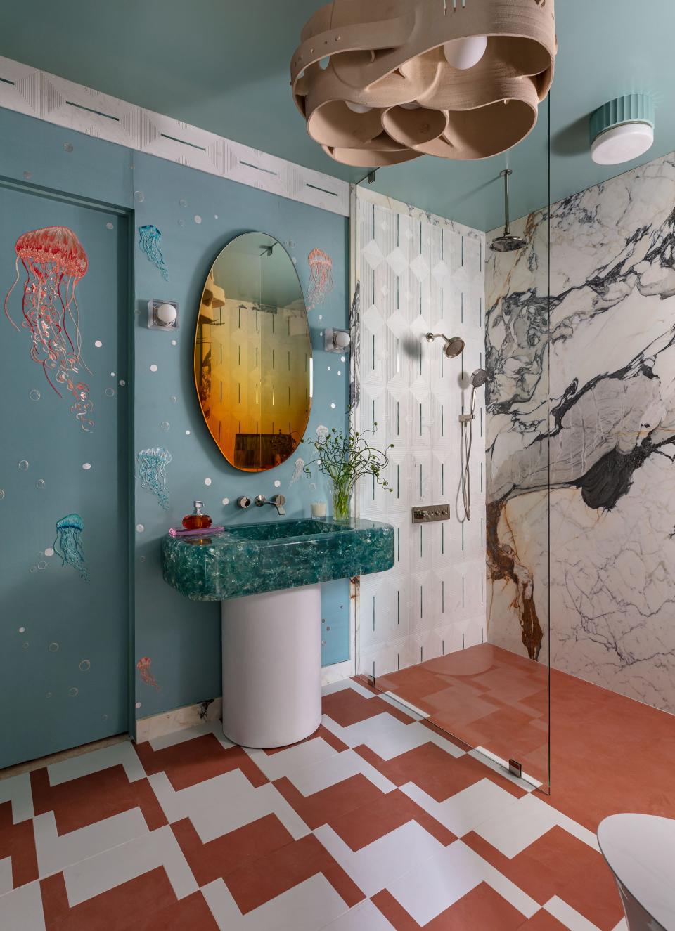 At the Kips Bay Decorator Show House Palm Beach, Helen Bergin's first-floor bathroom, with Kohler fixtures and faucets, features an underwater theme and a sink made of teal resin.