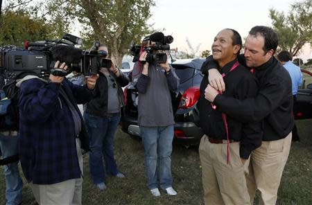 Darren Black Bear (2nd R) gets help with his tie from Jason Pickel as they ar esurrounded by TV cameras before being married by Darren's father Rev. Floyd Black Bear in El Reno, Oklahoma October 31, 2013. REUTERS/Rick Wilking