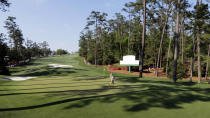 An unidentified patron runs across the 10th green during the third round of the Masters golf tournament Saturday, April 12, 2014, in Augusta, Ga. (AP Photo/David J. Phillip)