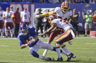 New York Giants quarterback Daniel Jones, left, dives through Washington Redskins defenders during the second half of an NFL football game, Sunday, Sept. 29, 2019, in East Rutherford, N.J. (AP Photo/Bill Kostroun)