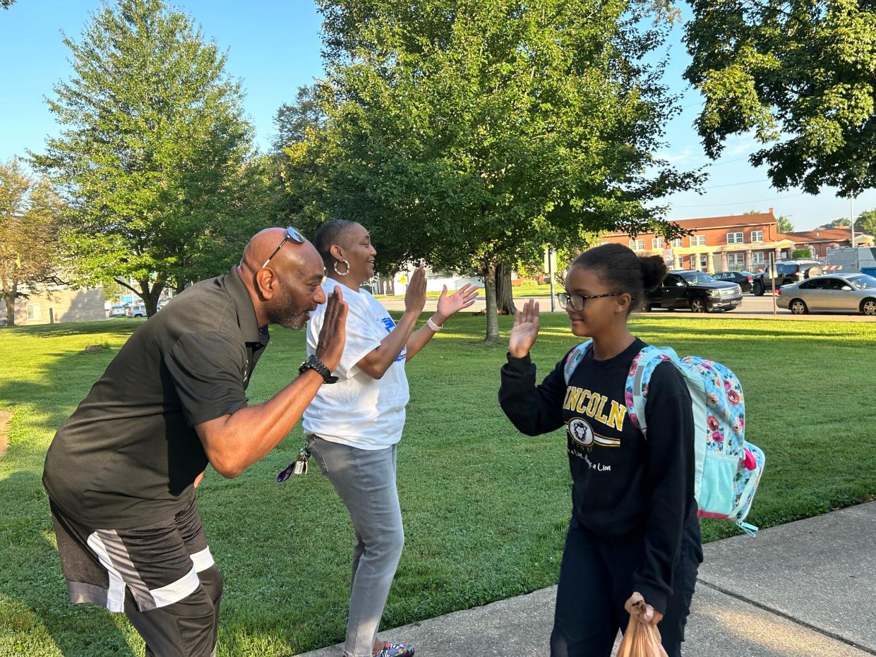 Talmadge Vick gets ready for a high five with student Jordan McIntosh.