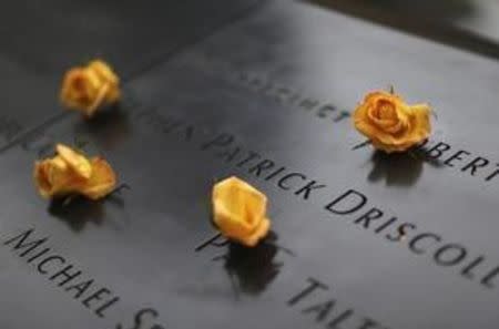 Flowers are seen left on the names of the victims of September 11, 2001 attacks on the World Trade Center at the South Tower Memorial Pool before memorial observances held at the site of the World Trade Center in New York, September 11, 2014. REUTERS/Chang lee/POOL