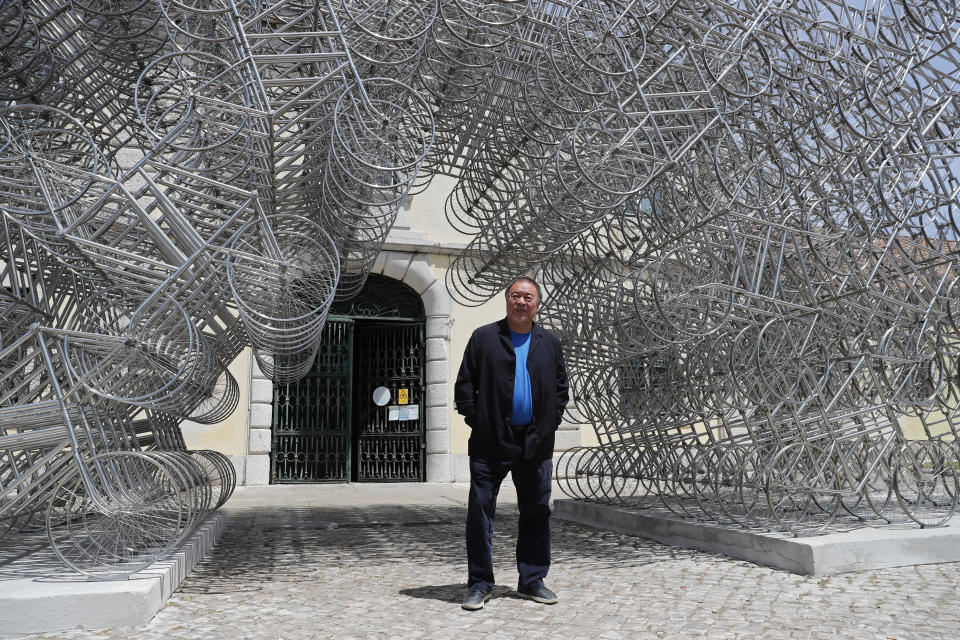 Dissident Chinese artist Ai Weiwei poses by his sculpture "Forever Bicycles" during a press preview of his new exhibition "Rapture" in Lisbon, Thursday, June 3, 2021. The world-renowned artist is putting on the biggest show of his career, and he is doing it in a place he's fallen in love with: Portugal. (AP Photo/Armando Franca)