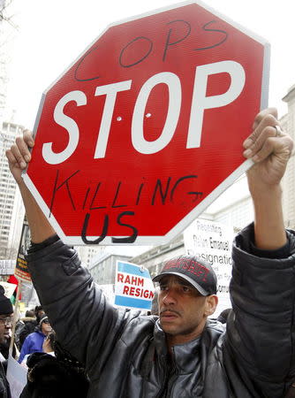 A protester holds a sign as they march down Chicago's Michigan Avenue during a protest march against police violence in Chicago, Illinois December 24, 2015. REUTERS/Frank Polich