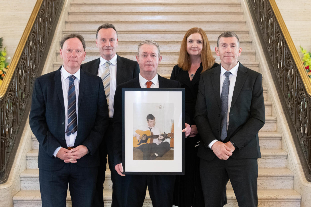 Shane, Conor and Paul McCormac with a picture of their late father John, accompanied by Ian Jeffers, commissioner for victims and survivors, and Jayne Brady (Pacemaker/PA)