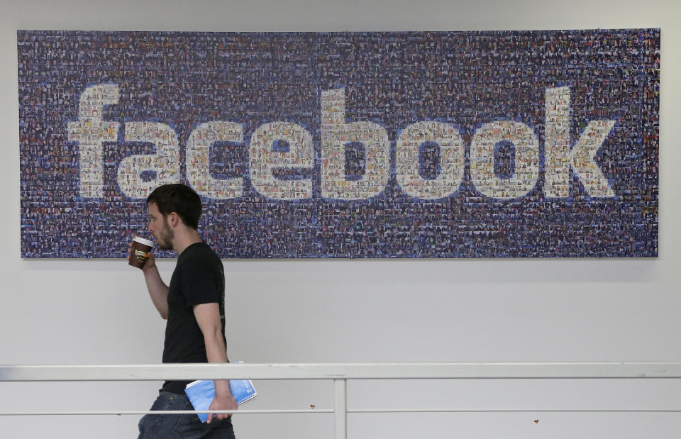 <p> FILE - In this March 15, 2013 file photo, a Facebook employee walks past a sign at Facebook headquarters in Menlo Park, Calif. Facebook Inc. said Thursday Oct. 10, 2013, that it is removing a setting that controls whether users could be found when people type their name into the website's search bar. (AP Photo/Jeff Chiu. File)</p>