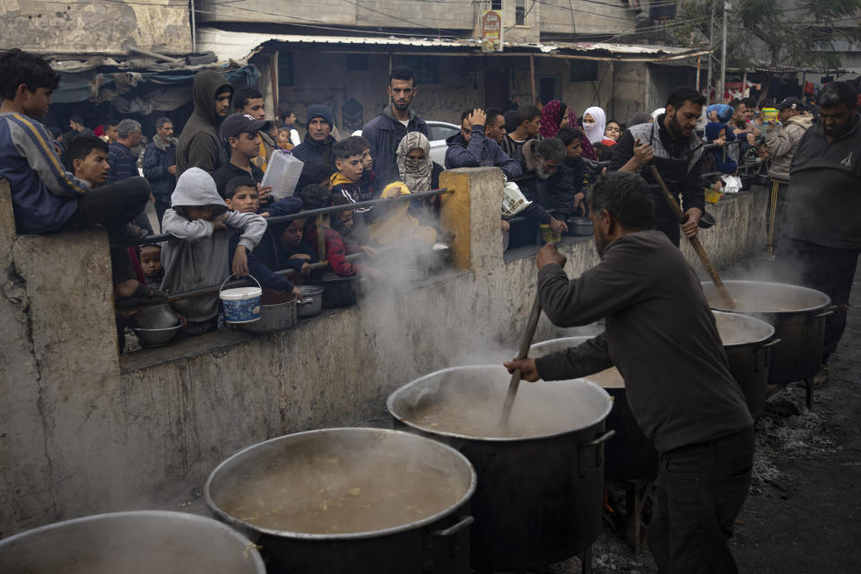 Palestinians line up for a free meal in Rafah, Gaza Strip, Thursday, Dec. 21, 2023. International aid agencies say Gaza is suffering from shortages of food, medicine and other basic supplies as a result of the two and a half month war between Israel and Hamas. (AP Photo/Fatima Shbair)