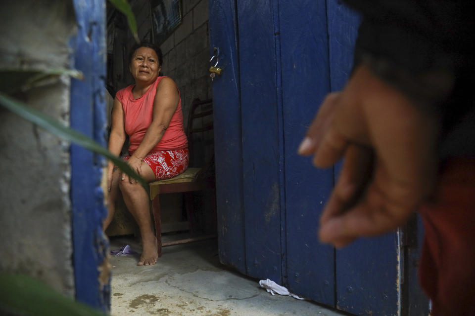 Una mujer se muestra nerviosa ante la llegada de la policía para entrar a su casa, parte de un operativo de búsqueda de armas y drogas con el fin de combatir a grupos criminales y extorsionadores, el jueves 4 de abril de 2024, en Guayaquil, Ecuador. (AP Foto/César Muñoz)
