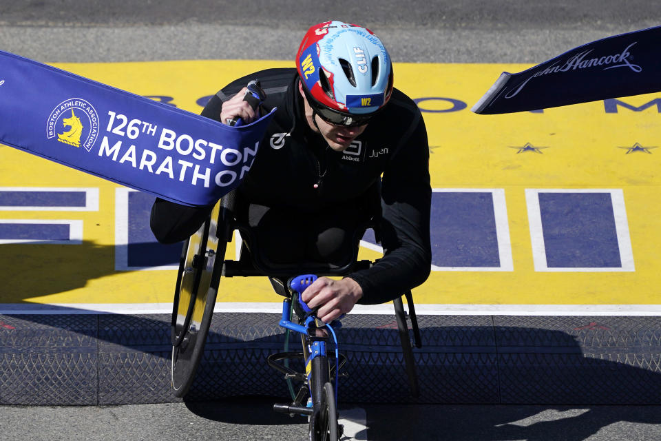 Daniel Romanchuk, of the United States, breaks the tape to win the men's wheelchair division of the Boston Marathon, Monday, April 18, 2022, in Boston. (AP Photo/Charles Krupa)