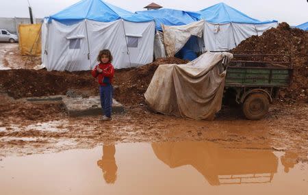 An internally displaced girl stands near a puddle of rain at the Bab Al-Salam refugee camp in Azaz, near the Syrian-Turkish border December 28, 2014. REUTERS/Hosam Katan