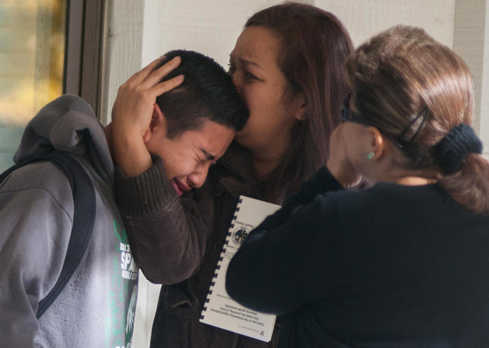 FILE - In this October 21, 2013 file photo, a Sparks Middle School student is comforted as he cries after being released from Agnes Risley Elementary School, where some students were evacuated to after a shooting, in Sparks, Nev. Although still relatively rare, there’s been no real reduction in the number of school shootings since security was beefed up around the country with measures such as safety drills and the hiring of police officers, after the rampage at Connecticut's Sandy Hook Elementary School in December 2012. (AP Photo/Kevin Clifford, File)