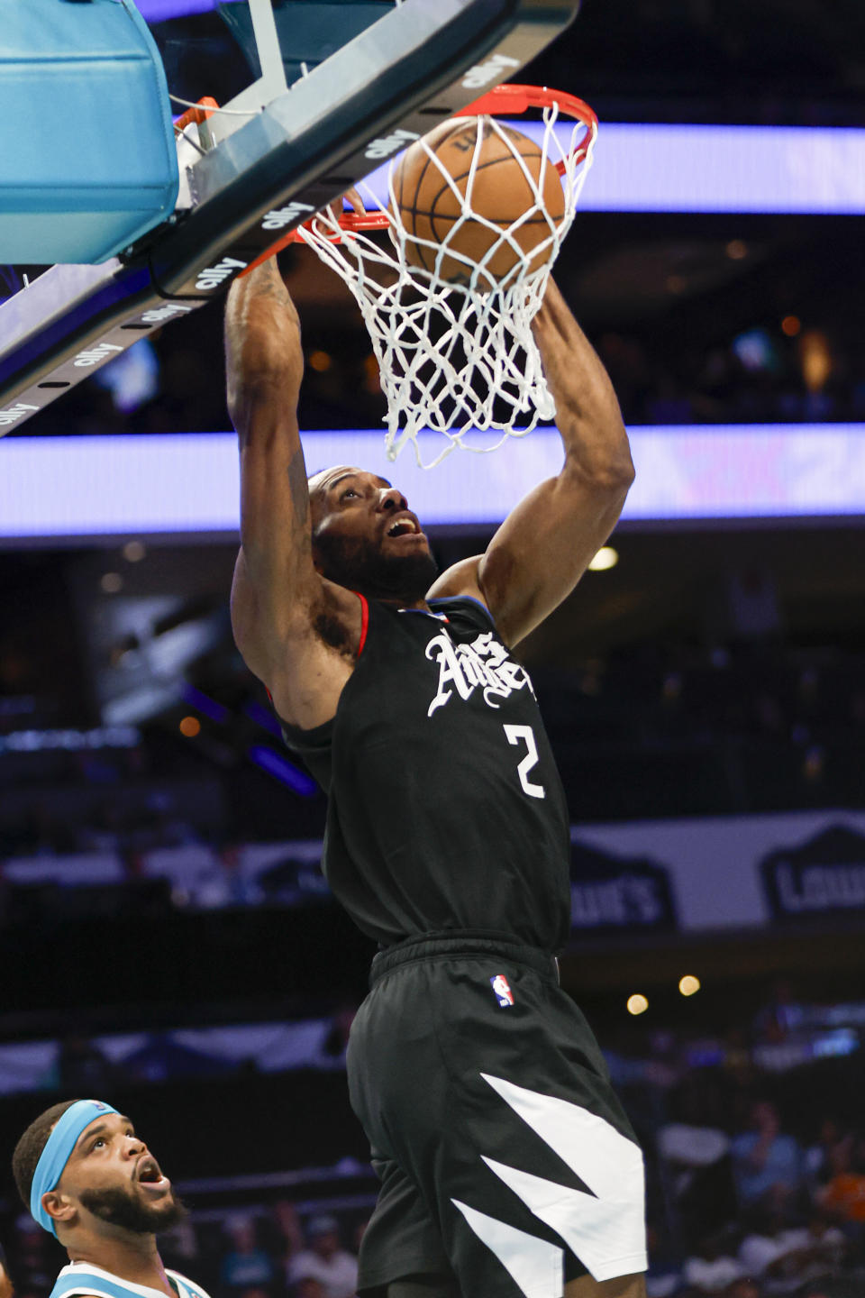 Los Angeles Clippers forward Kawhi Leonard, right, dunks as Charlotte Hornets forward Miles Bridges looks on during the first half of an NBA basketball game in Charlotte, N.C., Sunday, March 31, 2024. (AP Photo/Nell Redmond)