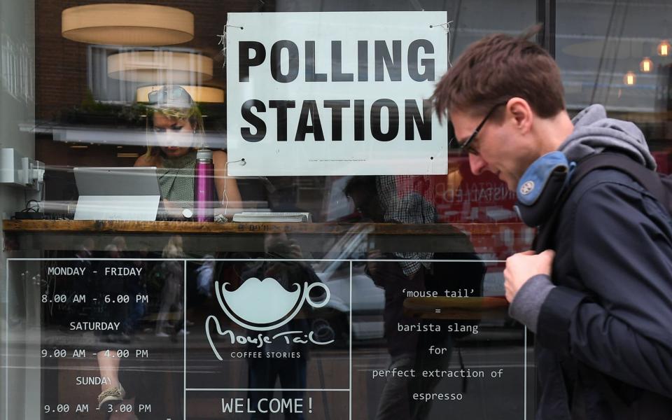 A man passes a coffee shop on London's Borough High Street serving as a polling station for the General Election, in June 2017 - EPA