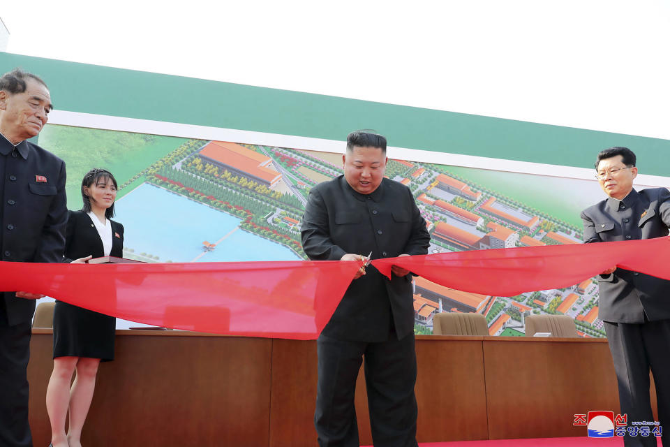 This photo shows North Korean leader Kim Jong Un, center, apparently cutting a tape during his visit to a fertiliser factory.