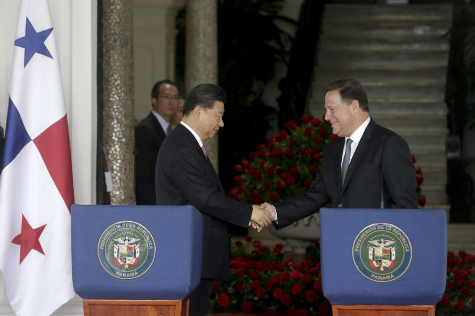 FILE - In this Dec. 3, 2018, file photo, Chinese President Xi Jinping, left, and Panama's President Juan Carlos Varela shakes hands after reading a statement and meeting at the presidential palace in Panama City. China’s expansion in Latin America of its Belt and Road initiative to build ports and other trade-related facilities is stirring anxiety in Washington. As American officials express alarm at Beijing’s ambitions in a U.S.-dominated region, China has launched a charm offensive, wooing Panamanian politicians, professionals and journalists. (AP Photo/Arnulfo Franco, File)