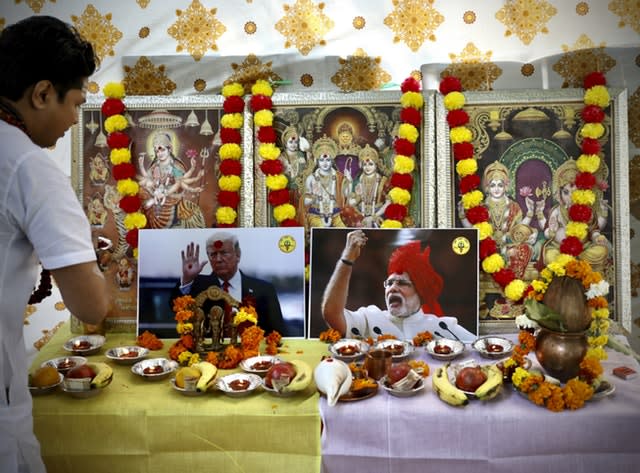 A Hindu priest performs prayers in front of portraits of US President Donald Trump and Indian Prime Minister Narendra Modi 