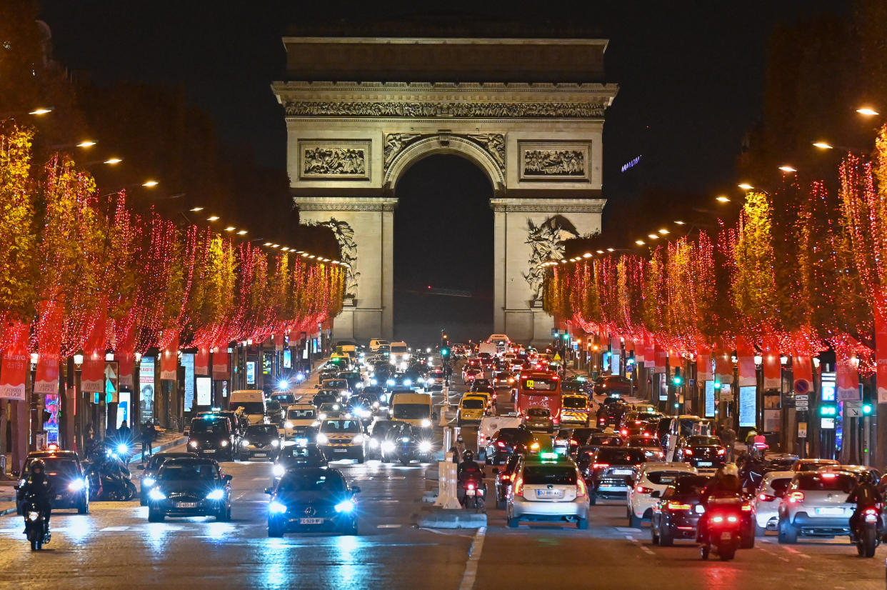 Christmas lights decorate the trees along the Champs-Elysees in Paris on Monday. Many European countries will this week unveil plans about how their citizens will be permitted to celebrate the holidays. (Photo: Stephane Cardinale - Corbis via Getty Images)