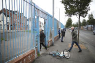In this Tuesday, Oct. 15, 2019 photo tourists with Belfast Political Tours walk into a Loyalist area in west Belfast, Northern Ireland. Fears about a return to the violence that killed more than 3,500 people over three decades have made Northern Ireland the biggest hurdle for U.K. and EU officials who are trying to hammer out a Brexit divorce deal. (AP Photo/Peter Morrison)