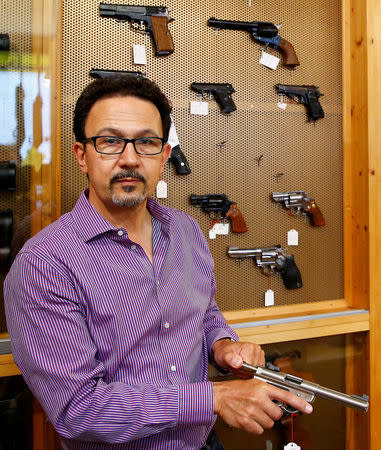 Daniel Wyss, president of the Swiss weapons dealers association, holds a Ruger gun in his Wyss Waffen gun shop in the town of Burgdorf, Switzerland August 10, 2016. REUTERS/Arnd Wiegmann