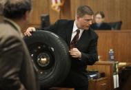 Massachusetts State Police Trooper Todd Girouard, holds a tire as he testifies during the murder trial of former New England Patriots football player Aaron Hernandez in Fall River, Massachusetts, March 5, 2015. REUTERS/Steven Senne/Pool