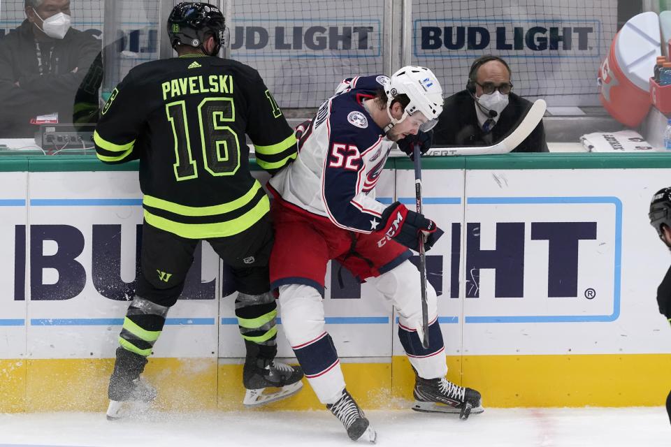 Dallas Stars center Joe Pavelski (16) and Columbus Blue Jackets center Emil Bemstrom (52) work again the boards for control of the puck in the second period of an NHL hockey game in Dallas, Saturday, March 6, 2021. (AP Photo/Tony Gutierrez)